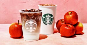 Photo showing an iced macchiato and a hot latte from Starbucks next to a pile of red apples on a pink background