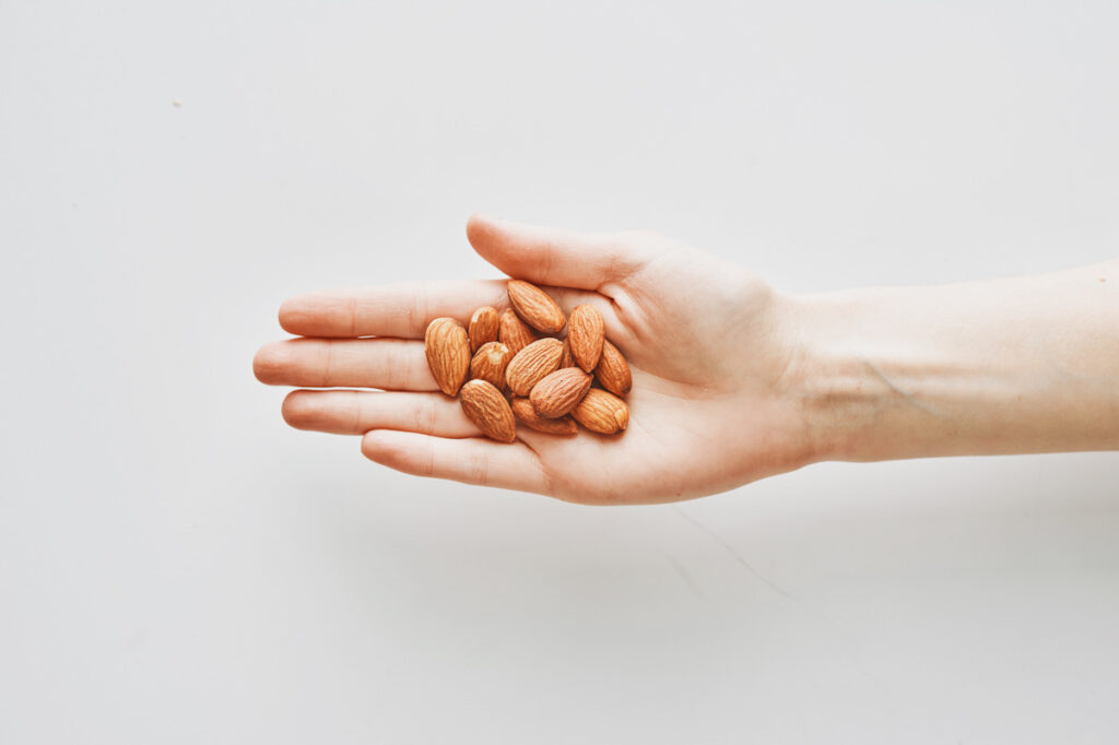 Photo shows a hand holding almonds, which are a good source of calcium.
