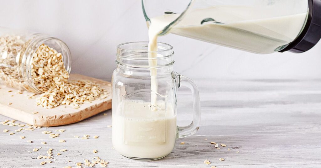 DIY oat milk being poured into a glass