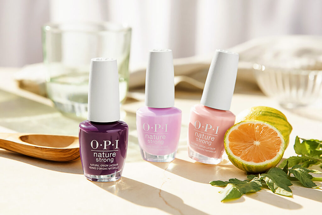 Photo shows OPI's vegan nail polish collection on a table next to citrus and leaf garnishes.