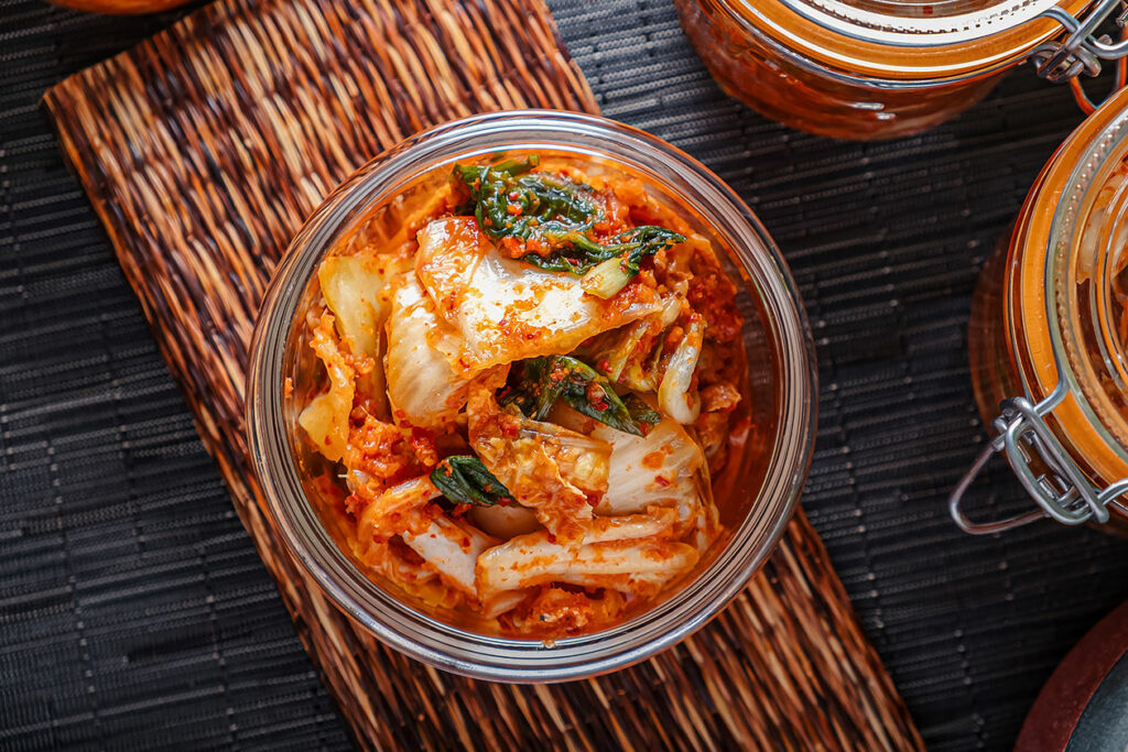 Bowl of spiced kimchi on a wicker mat.