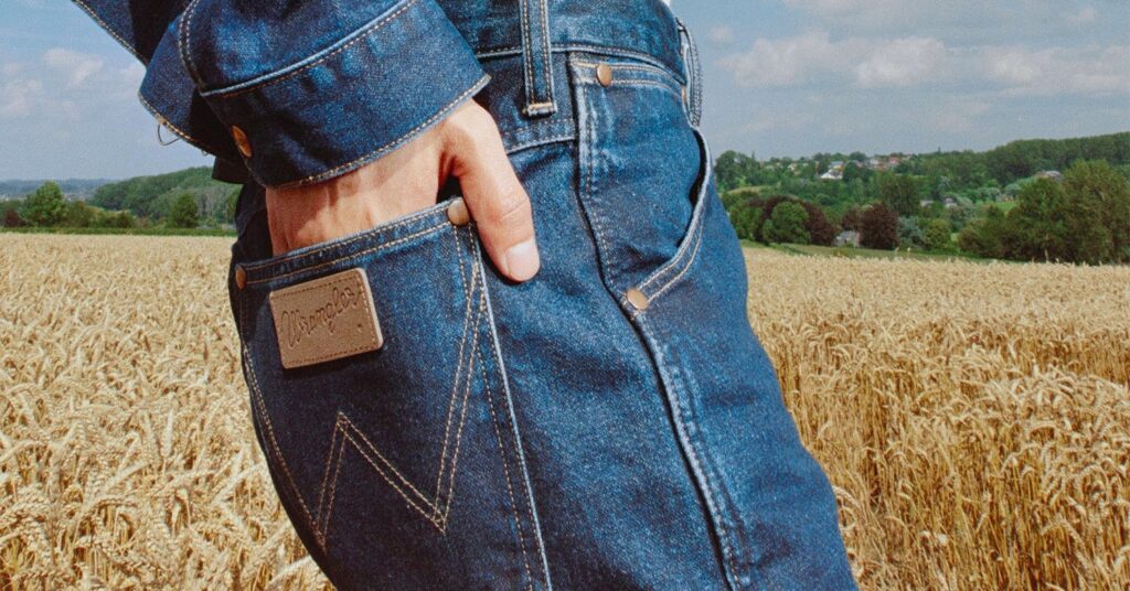 Photo shows someone wearing Wrangler jacket and jeans, focused on their mid-section and upper legs. Wrangler is introducing its most sustainable denim yet for the Fall 2021 collection.