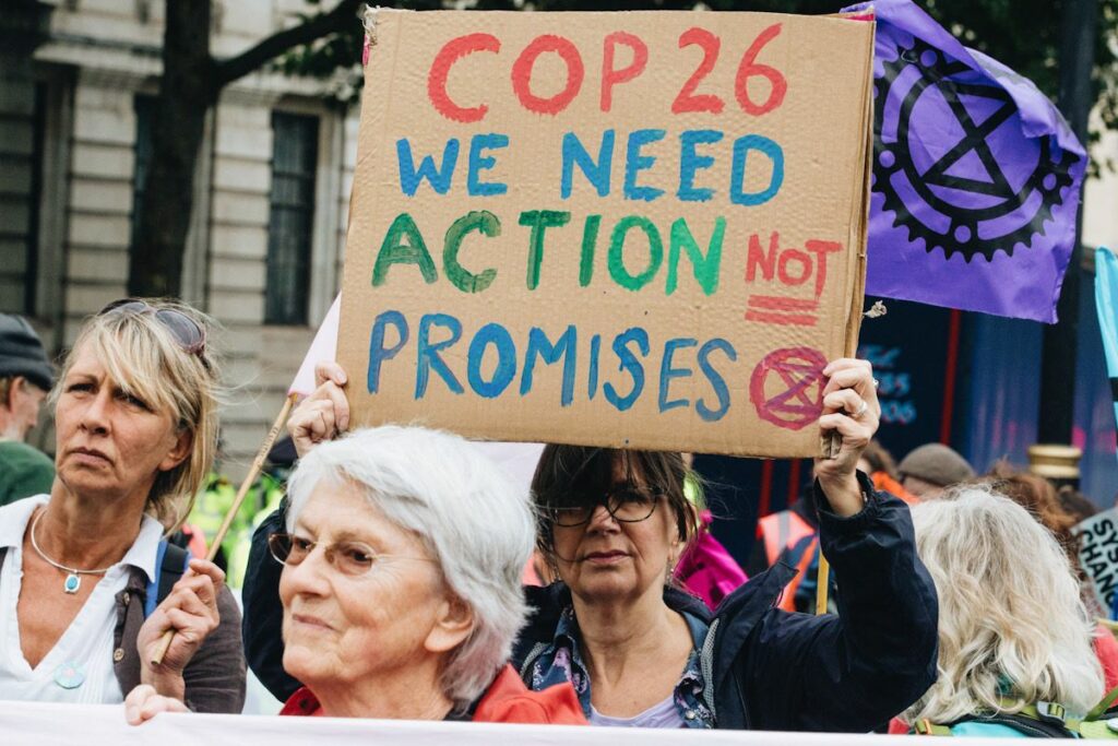 Photo of protestor with the activist group Extinction Rebellion calling for COP26 to take action, not make promises