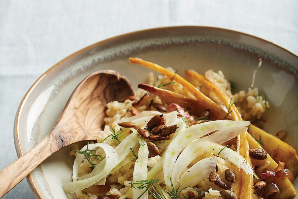 Photo of a brown rice bowl with maple-roasted parsnips, shallots, and spicy pumpkin seeds