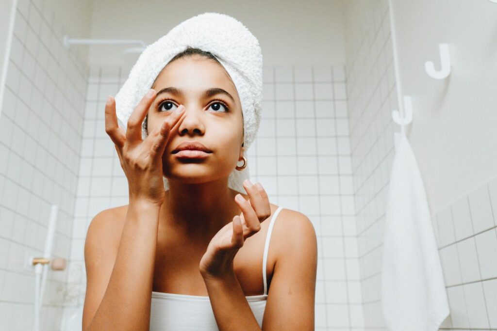 A woman applying skincare in the bathroom