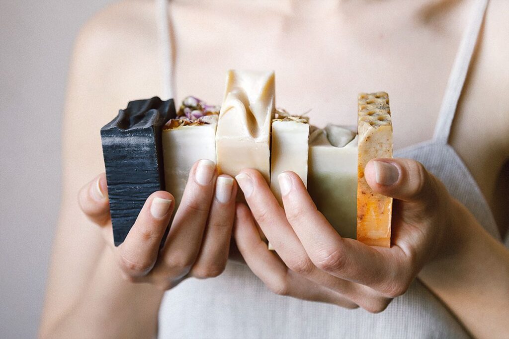 A woman holds several bars of soap 