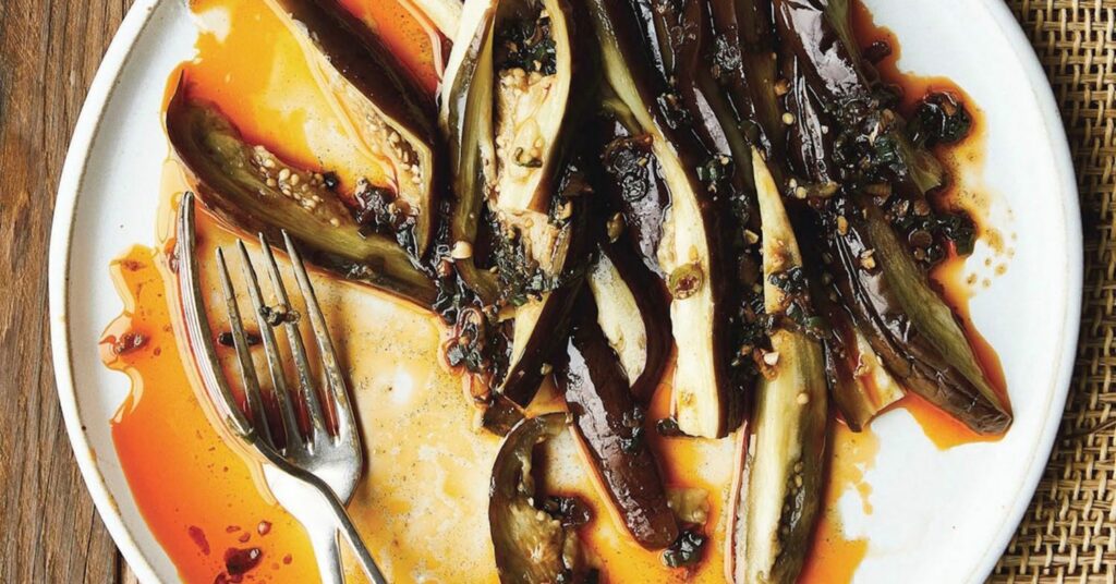 The eggplant on a plate served with a smoky green onion oil sauce.
