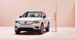 Photo of a silver Volvo electric car charging against a pink background