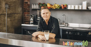 Photo shows Bryan Adams drinking a glass of Bettermood's Moo Drink—a plant-based oat milk.