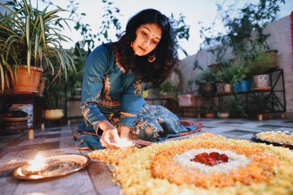 A Hindu woman lights a candle during divali