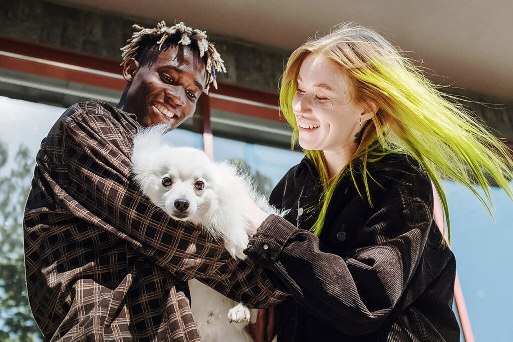 man and woman holding dog