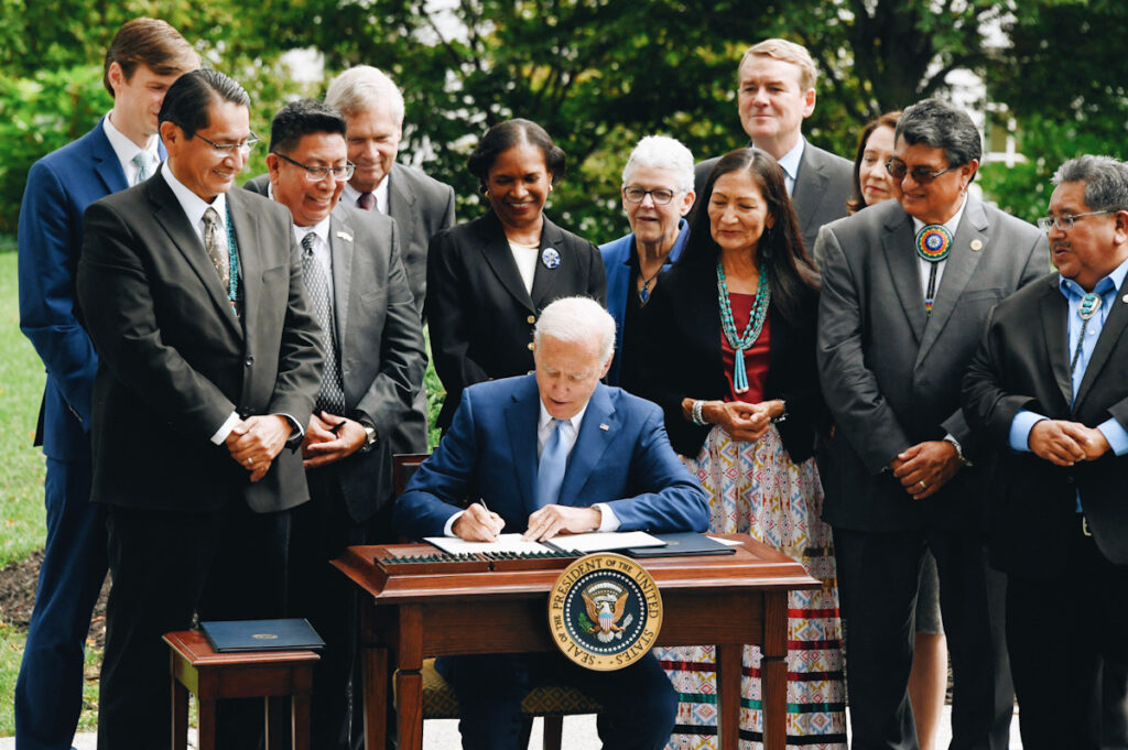 Photo shows U.S. President Joe Biden with Interior Secretary Deb Haaland as he signs three proclamations to restore National Park protections—a notable good climate news story from 2021.