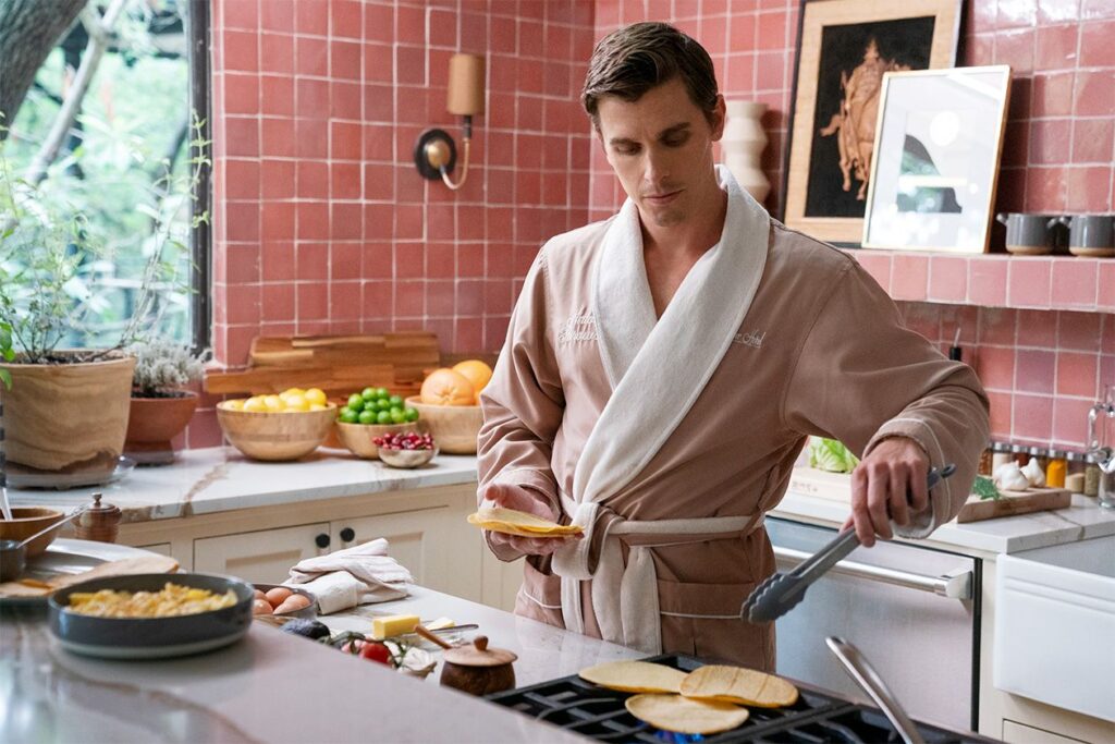 Photo shows Antoni Porowski heating up tortillas on a stove