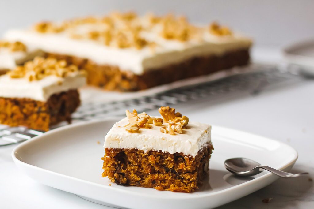 Photo shows a vegan carrot cake slice on a plate