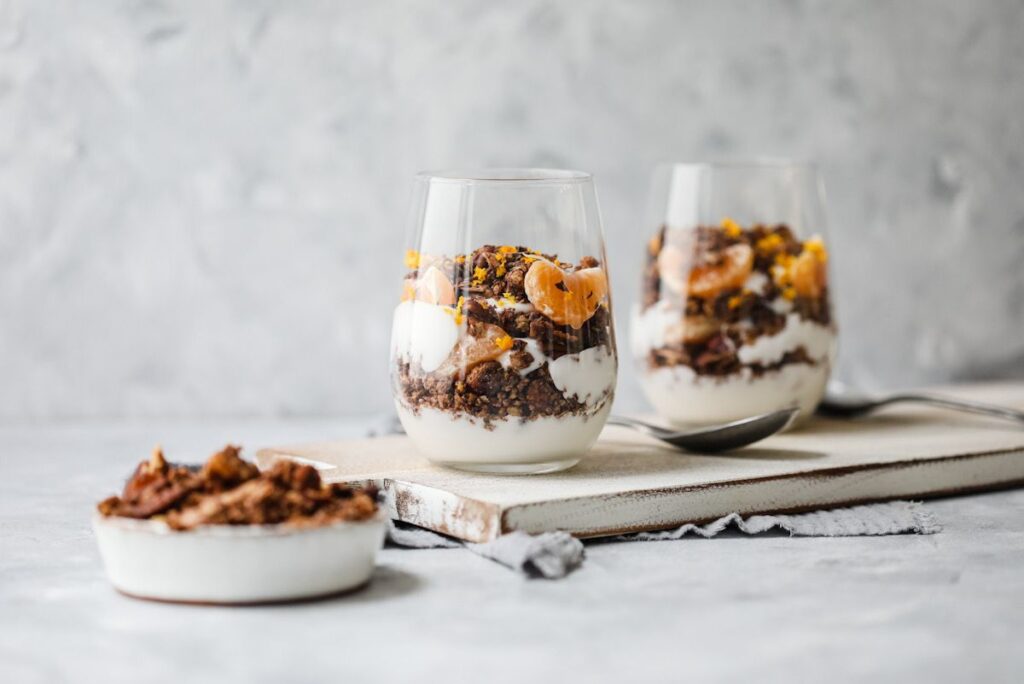 A wooden board with granola in glasses