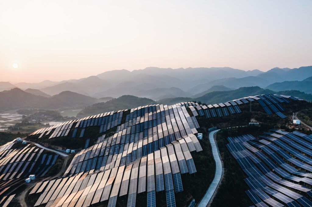 Photo shows fields of solar panels spread over a hillside with mountains in the background. The IPCC's latest climate change report reiterates that renewable energy is key.