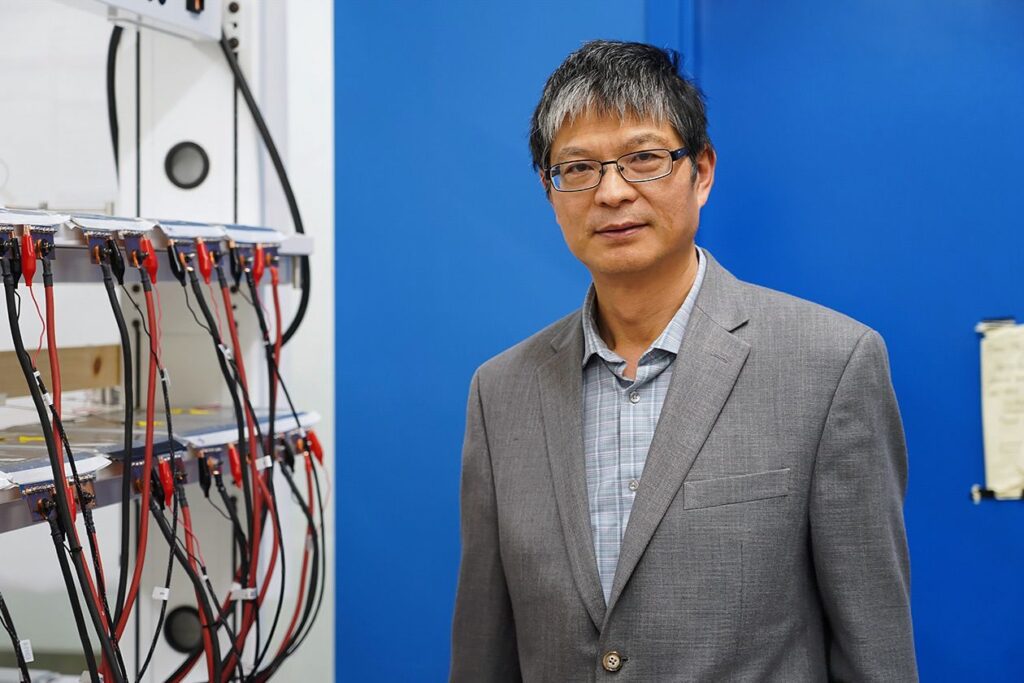 Photo shows professor Chris Mi on a blue background