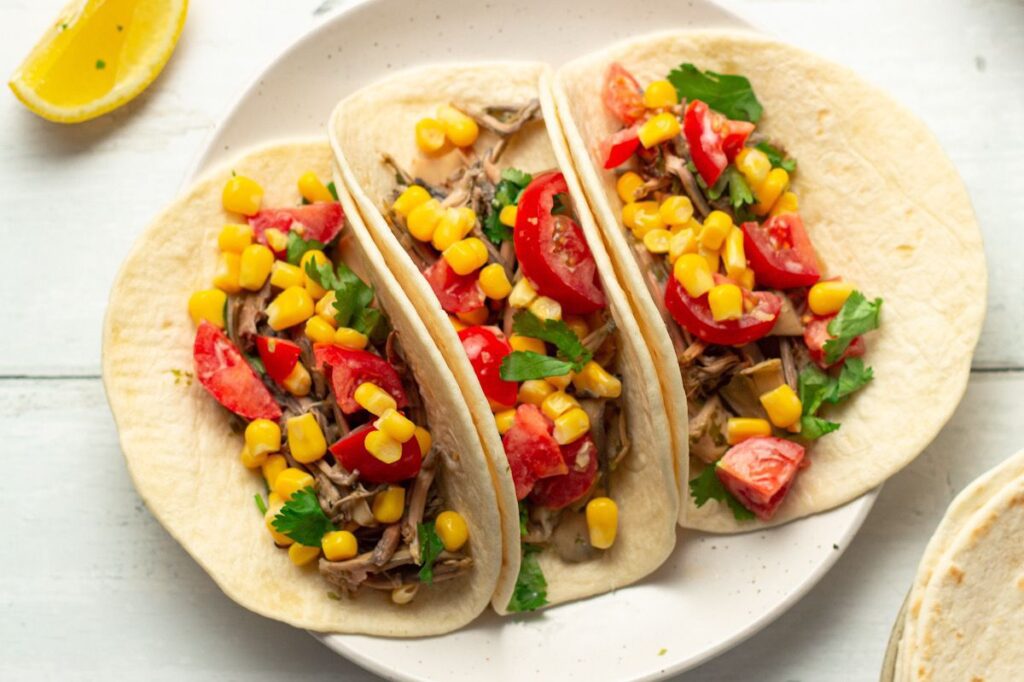 Photo shows vegan fish tacos topped with corn salsa