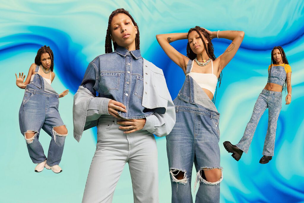Photo shows H&M models standing in distressed denim clothes against a tie-dye style background.