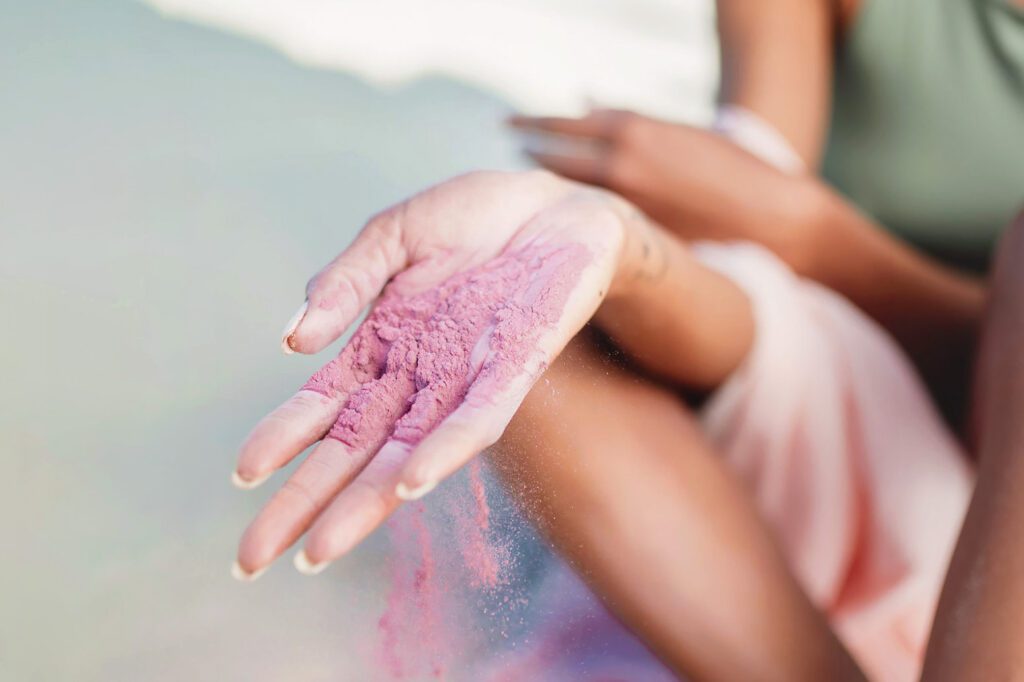 Photo shows someone with a handful of purple dye powder made from sustainably farmed algae.